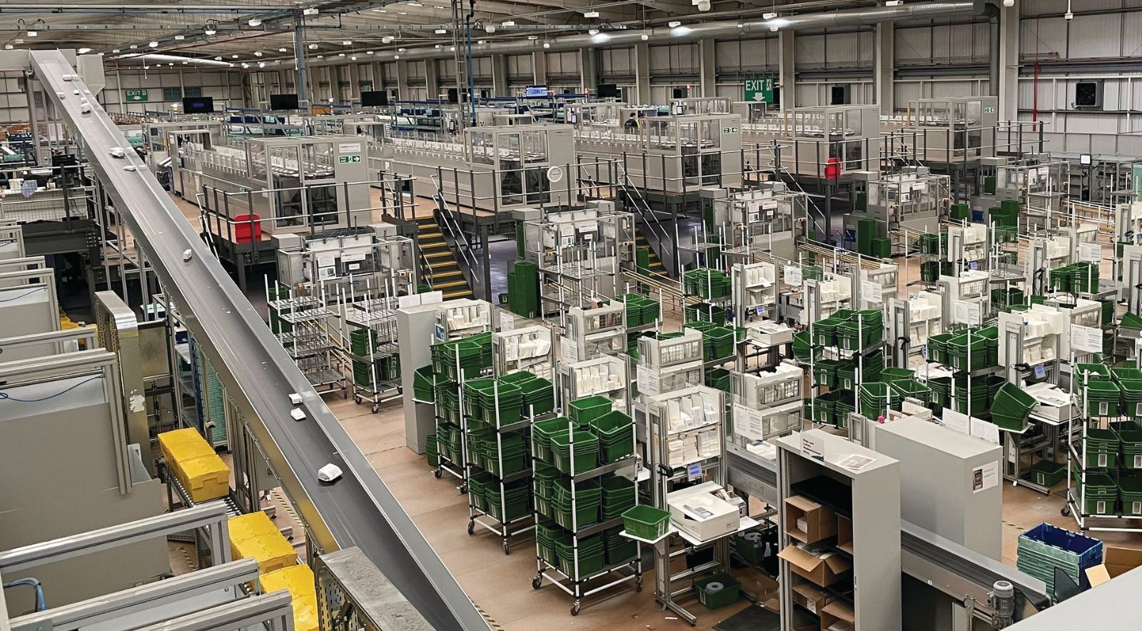 A large central fill operation already running, totes staged across the floor