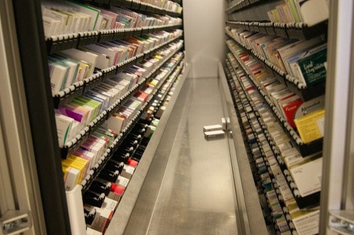 Inside a RoboPharma unit-of-use system, packaged medications either side of the integrated conveyor
